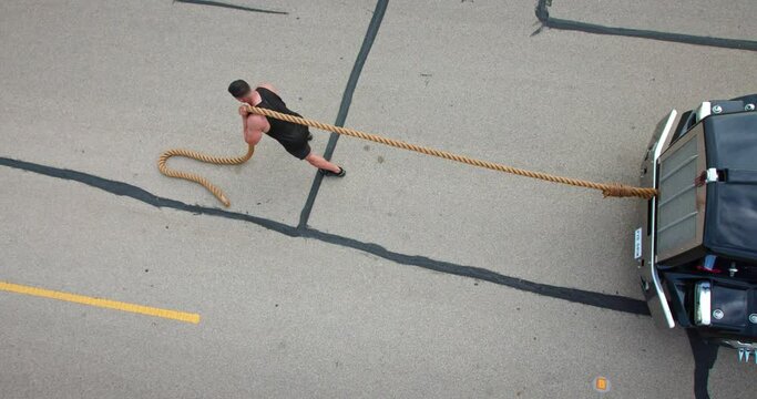 Body builder pulls a truck with a large rope