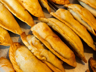View of fresh empanadas with cheese and jamon displayed in pastry shop