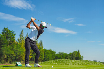 Asian man golfing on the course in summer - Powered by Adobe