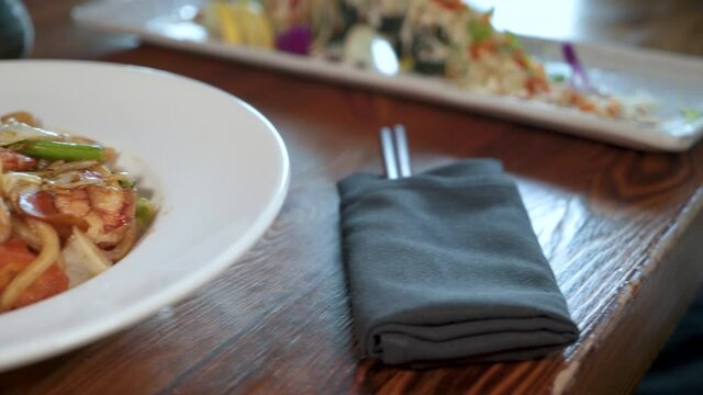 Japanese restaurant tabletop with shrimp udon bowl, sushi roll, chopsticks, slider 4K