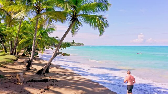 Caucasian Man Walking In Quiet Beach In Playa Bonita, Dominican Republic - wide shot