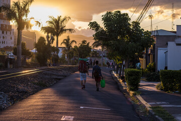 horizontal shot of two backpackers tourists walking in the city of San Jose in Costa Rica with a...