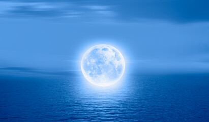 Naklejka na ściany i meble A full moon floating calmy over the sea 