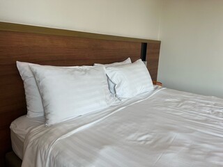 Soft pillows on the white mattress in the double bedroom of luxury hotel for couple