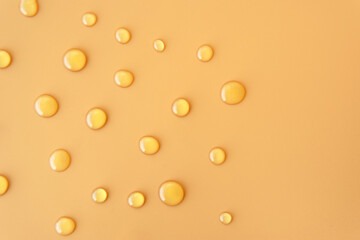 flatlay top view sweet Honey texture drop round shape on plain light orange yellow color background. Skincare ingredient for antibacterial and suitable for acne prone oily sensitive or all skin types