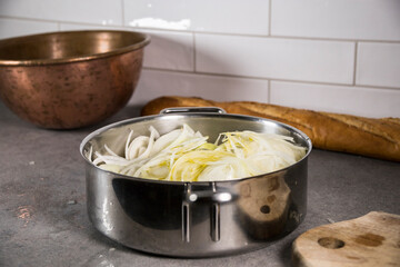Fresh chopped onions frying in oil in a saucepan