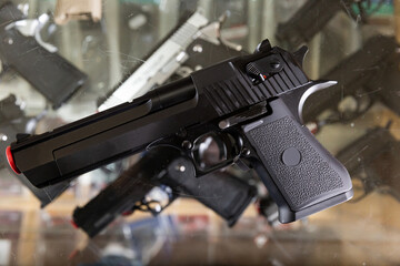Obraz premium Pistol on showcase in weapon shop. Exemplar of firearm weapon.