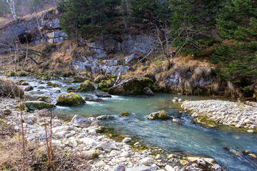 autumn morning, walking along the bed of a mountain river that has become shallow by the beginning...