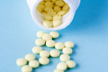 Medical pills and tablets spilling out of a drug bottle.