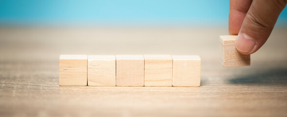 Man hand holding a wooden block lay on table, marketing ideas, business concept, economic growth.