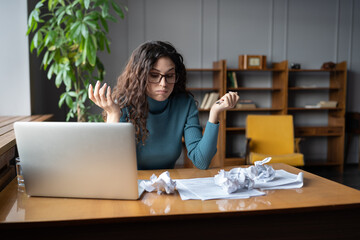Stressed female accountant having troubles at work, sitting at messy office desk with crumpled paper, cant deal with deadline for preparation of financial report, overworked businesswoman in stress - obrazy, fototapety, plakaty