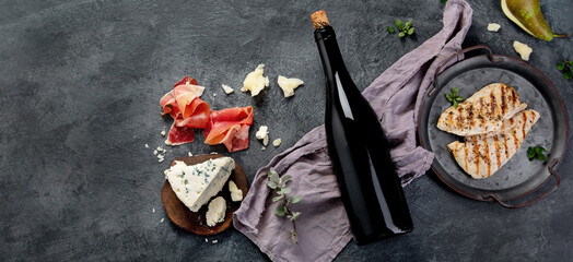 Red wine Sirah with appetizers on gray background.