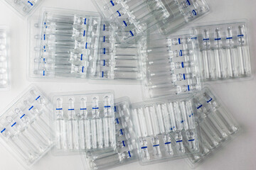 plastic transparent containers with glass ampoules on a white background