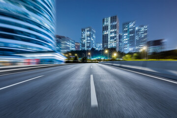 Motion blurred asphalt road and modern commercial building landscape in Beijing, China.