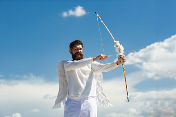 Valentin with bow arrow ready to shoot. Funny bearded man with feathers wings of Cupid Valentines...