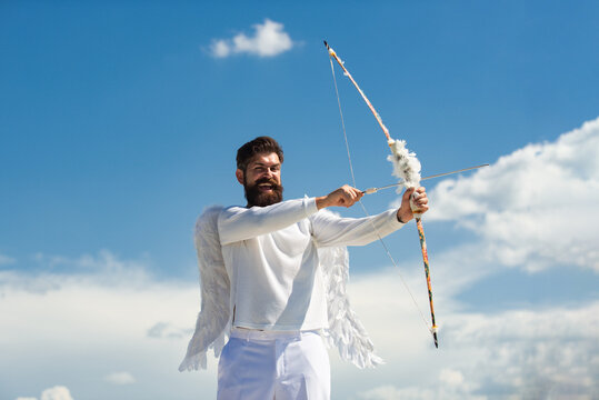 Valentin with bow arrow ready to shoot. Funny bearded man with feathers wings of Cupid Valentines Day.