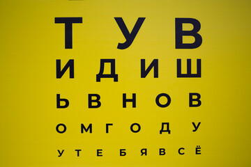 Eyesight test chart background . Russian letters on an yellow background