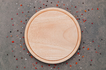 Empty pizza platte with spices set up on dark concrete background flat lay and copy space.