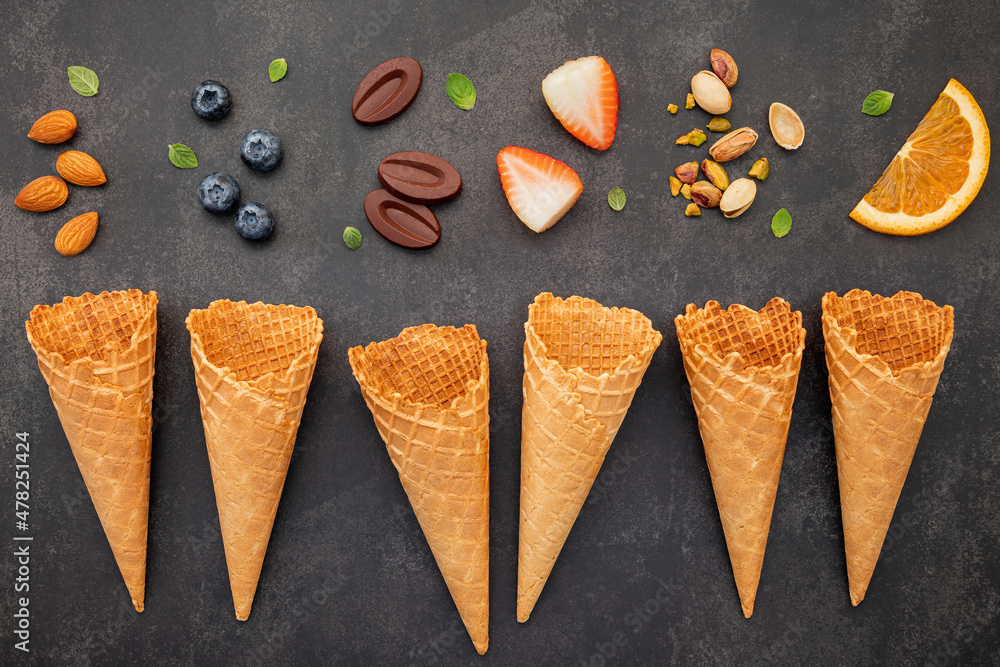 Fototapete Flat lay ice cream cones collection on dark stone background . Blank crispy ice cream cone with copy space for sweets menu design.