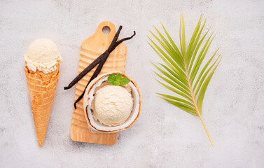 Fototapeta na wymiar Coconut ice cream flavours in half of coconut setup on white stone background. Summer and Sweet menu concept.