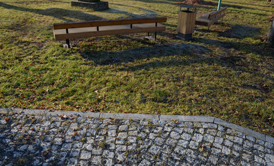 wooden long bench, where the seating area is formed by rows of vertical planks and a backrest....