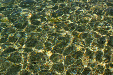 Fototapeta na wymiar texture sea water in the rays of the sun green tint