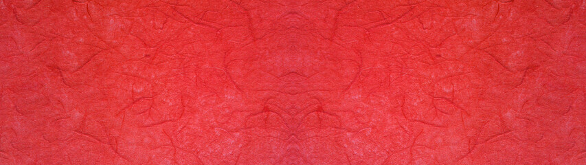 赤色の手漉き和紙の表面のテクスチャー。横に長いパノラマの背景素材。