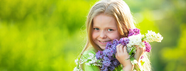Banner with spring kids portrait. Teenager girl with bouquet of lilac. Funny teenager girl having fun outdoors. Spring blossom.