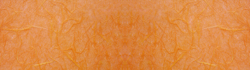 橙色の手漉き和紙の表面のテクスチャー。横に長いパノラマの背景素材。