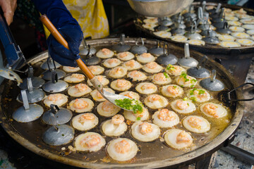 Sizzling Vietnamese mini shrimp pancake and onion- Vietnamese cuisine, Banh Khot. Vendor hawker...