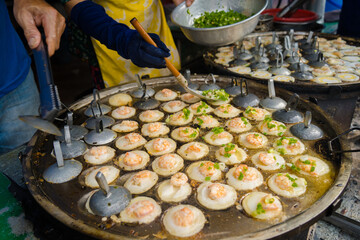 Sizzling Vietnamese mini shrimp pancake and onion- Vietnamese cuisine, Banh Khot. Vendor hawker...