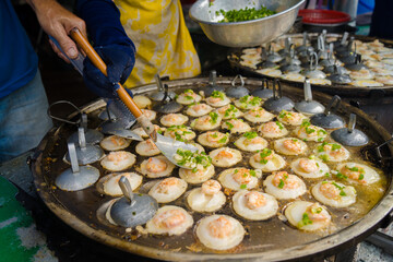 Sizzling Vietnamese mini shrimp pancake and onion- Vietnamese cuisine, Banh Khot. Vendor hawker...