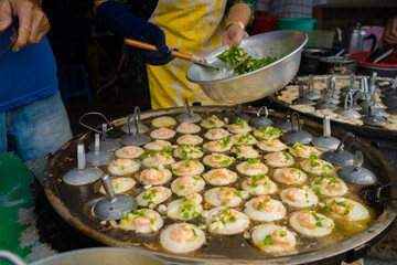 Sizzling Vietnamese mini shrimp pancake and onion- Vietnamese cuisine, Banh Khot. Vendor hawker...