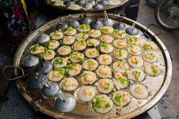 Sizzling Vietnamese mini shrimp pancake and onion- Vietnamese cuisine, Banh Khot. Vendor hawker...