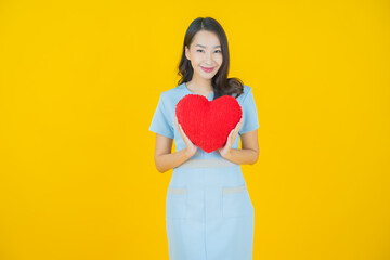 Portrait beautiful young asian woman smile with heart pillow shape