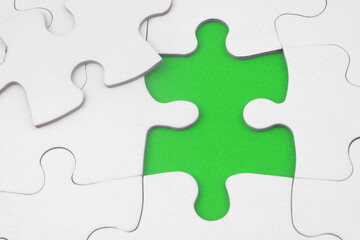 White jigsaw puzzles, one piece disconnected. Business strategy, teamwork, problem solving and complete mission concept.