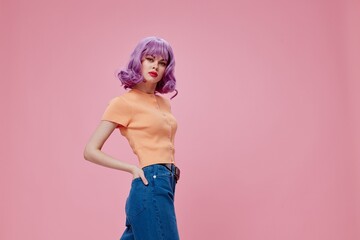 pretty glamorous woman purple hair in jeans pink background