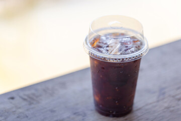 Glass of iced americano coffee on wooden table