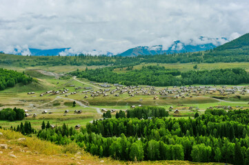 Mountains and forests surround the natural scenery of Hemu village in Kanas, Xinjiang, China - obrazy, fototapety, plakaty