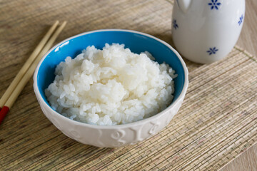 Japanese steamed Uruchimai rice in a pretty ceramic bowl with chopsticks