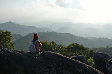 Fototapeta premium Female tourist sits looking at the beautiful mountains view.