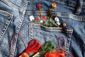 Creative DIY project, hand embroidery at home on jeans, creative hobby, clothes recycle, floral...