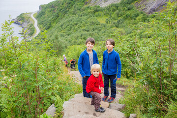 Children, toddler, brothers and father, climbing the stairs to Reinebringen, trekking path leading...