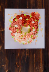 Amazing top view of tasty cake with fascinating topping decorated by cream in colorful and lovely roses.