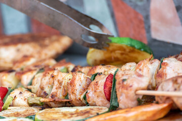 Chicken breast and pork meat pulled in wooden skewer with fresh colorful and tasty vegetables
