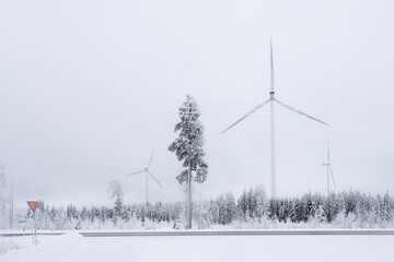 Windmills in Finland. White winter landscape with snow producing green and sustainable energy