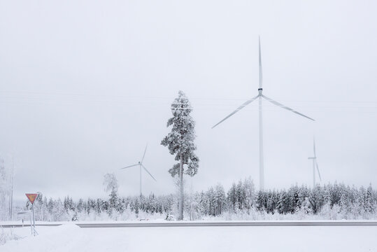 Windmills in Finland. White winter landscape with snow producing green and sustainable energy - Powered by Adobe