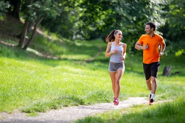 Foto op Plexiglas Portret van gelukkige fitte mensen die samen door onze deuren rennen. Paar sport gezonde levensstijl concept © NDABCREATIVITY