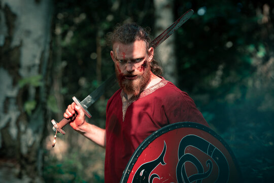 Brave viking showing sharp sword for historic reenactment
