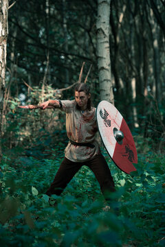 Dirty woman with shield and spear at reconstructed battle